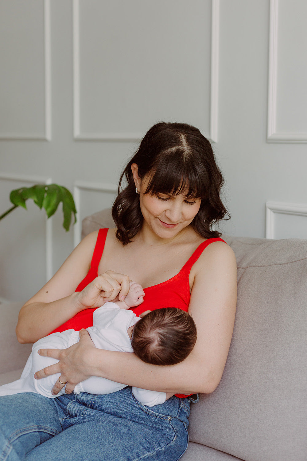Mujer cargando un bebe usando una blusa color rojo.