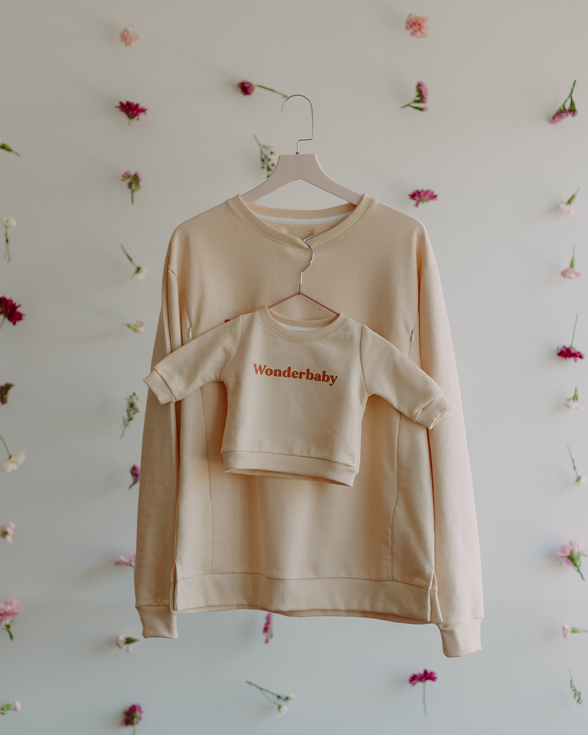 Dos polos color vainilla manga larga. Uno es de talla adulta y el otro de talla de bebe.