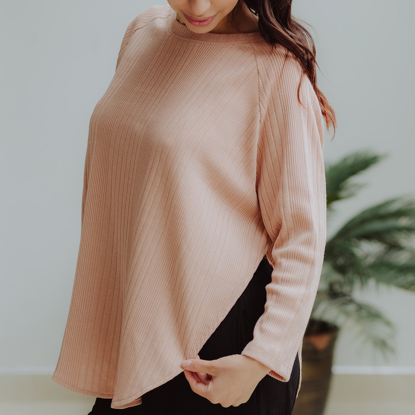Mujer embarazada usando un polo manga larga color blush.