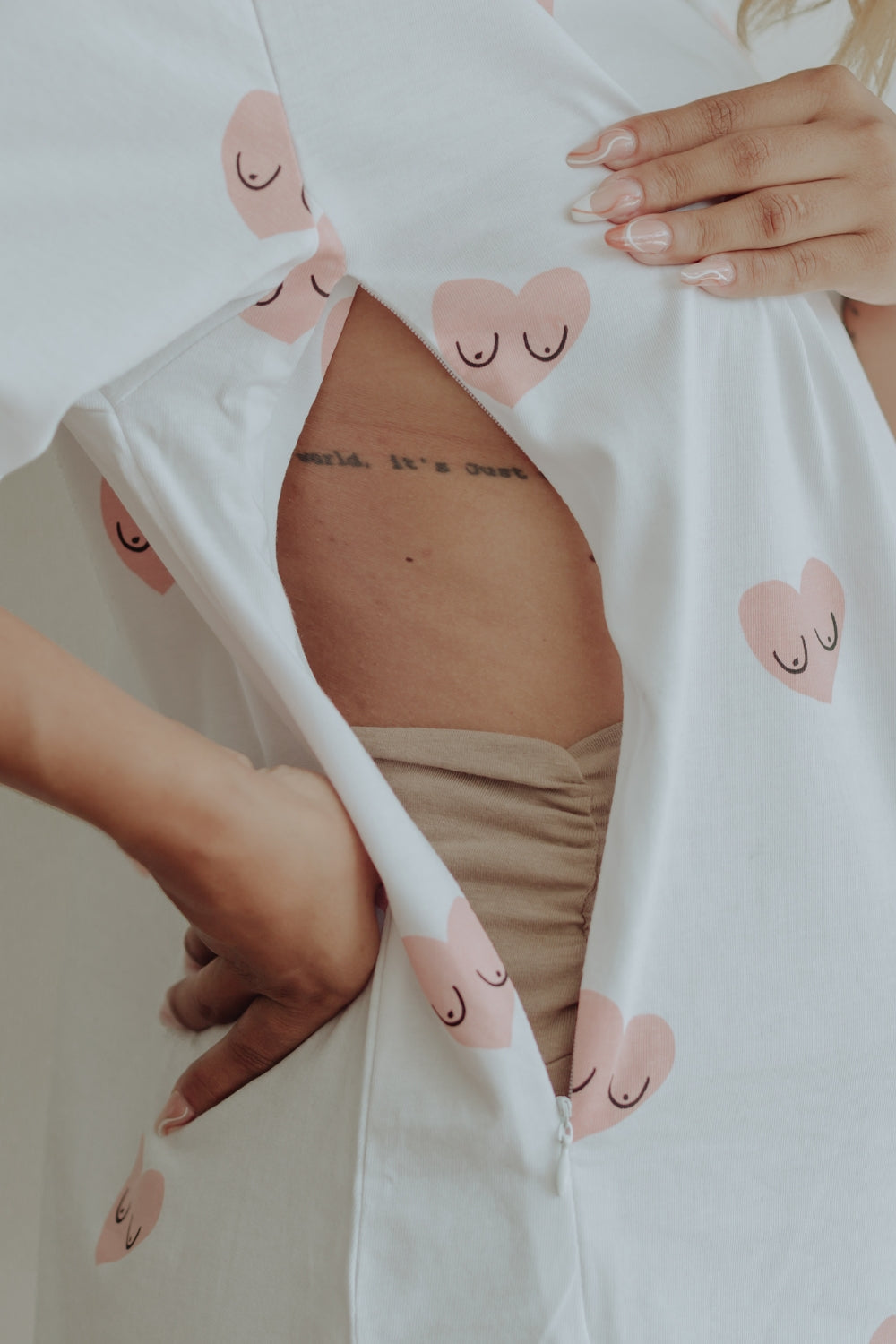 Mujer usando un polo largo de manga corta, en color blanco con estampado de corazones