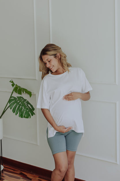 Mujer embarazada usando un biker short color verde cemento.