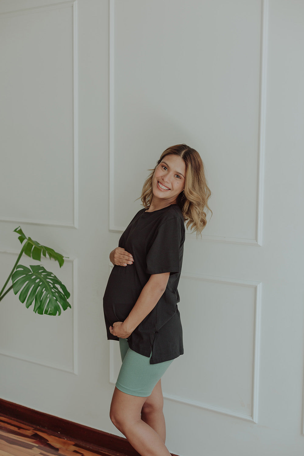 Mujer embarazada usando un biker short color verde cemento.