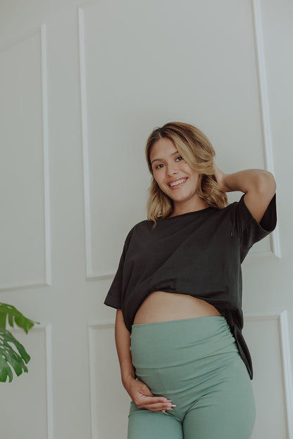 Mujer embarazada usando un biker short color verde cemento.