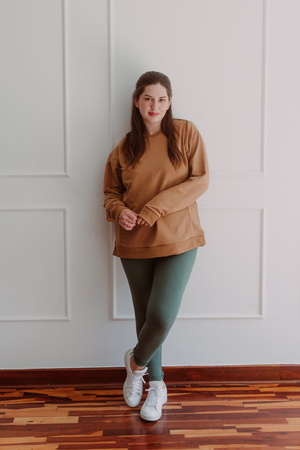 Mujer embarazada usando unos leggins en color dark green.