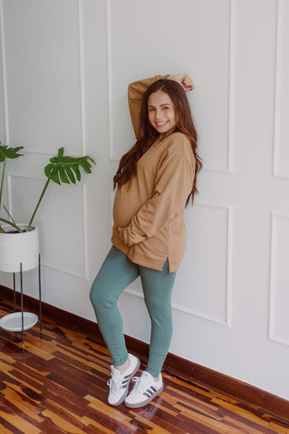 Mujer embarazada usando unos leggins en color dark green.