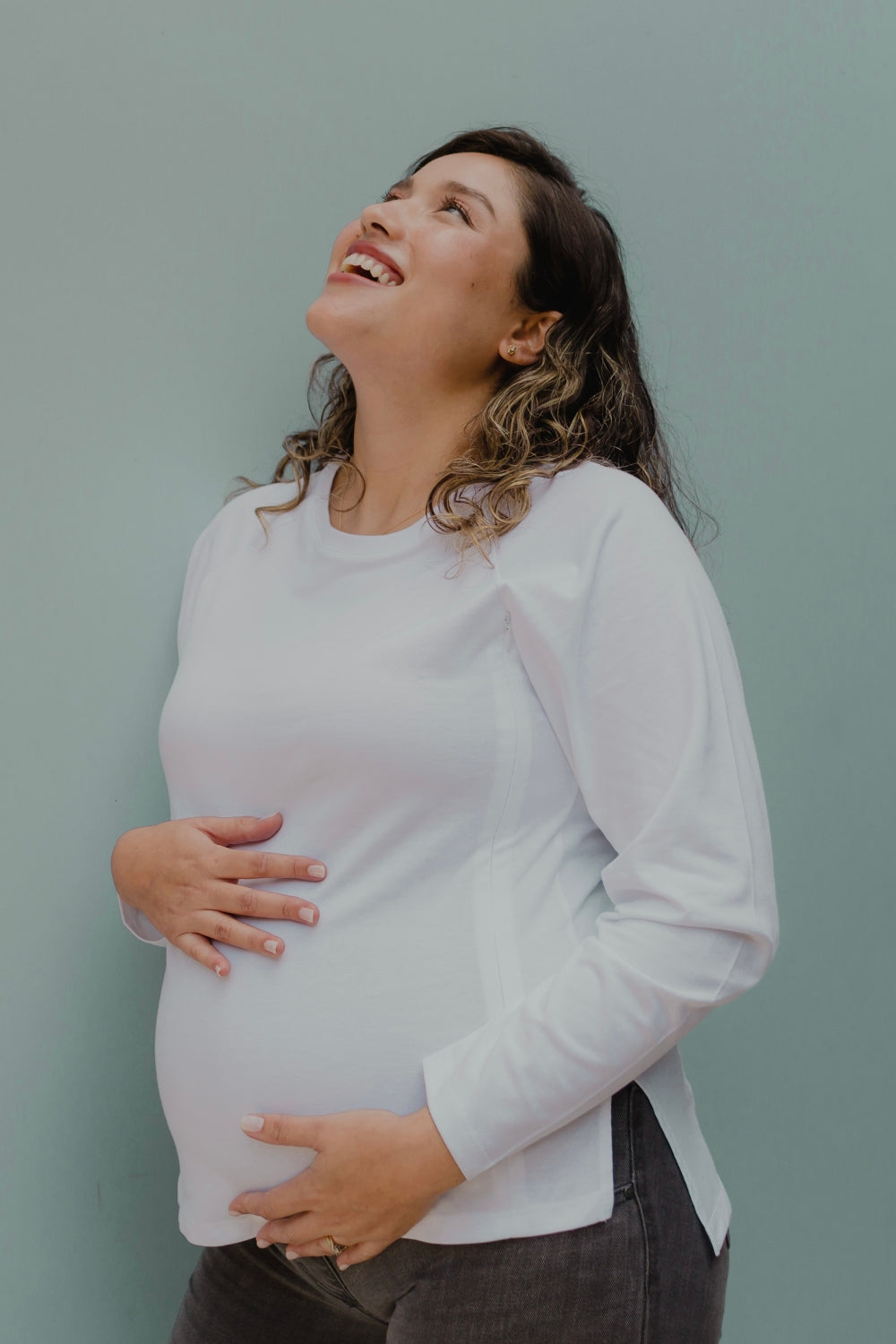Mujer embarazada usando un polo de manga larga en color blanco.