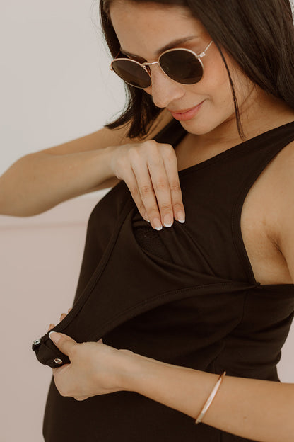 Mujer emabrazada usando un vestido negro.